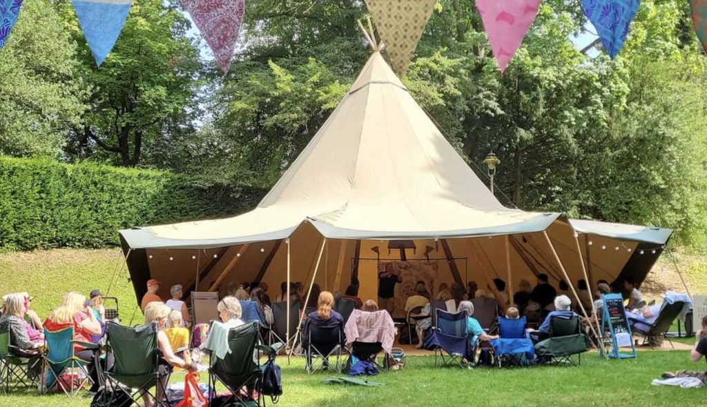Alex Crump performing stories at an open air storytelling event.